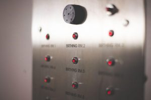 Hospital birthing room control panel with indicator lights and buttons.